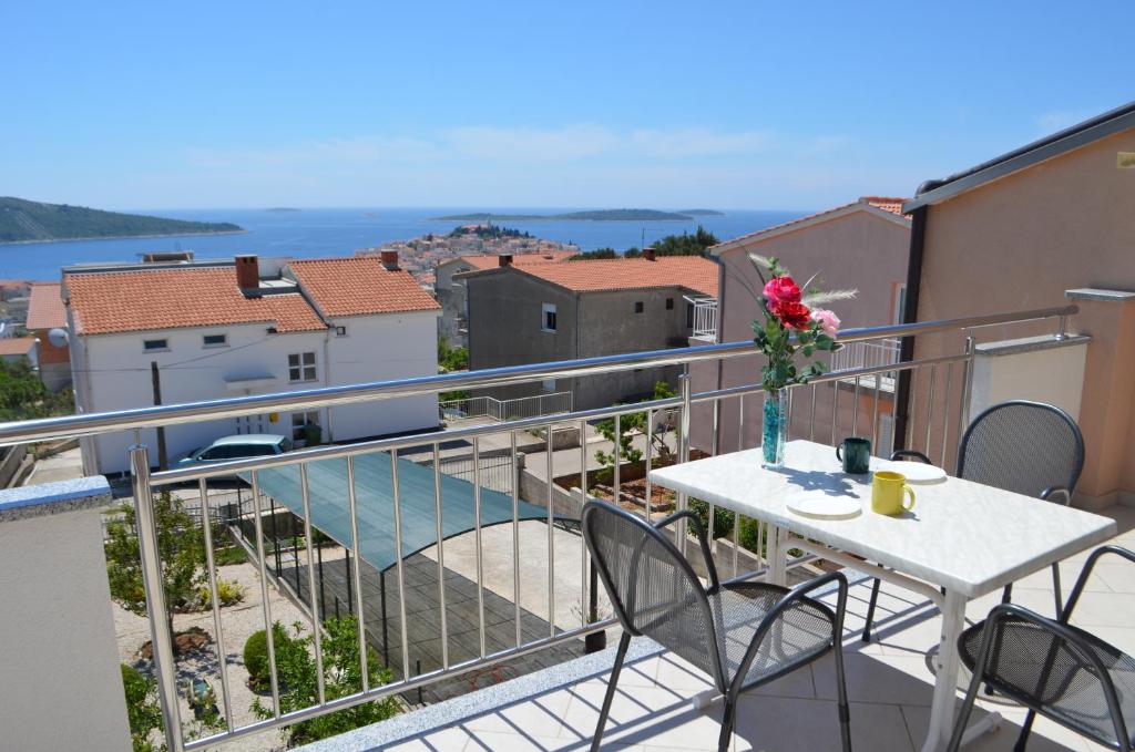 Un balcón con una mesa con flores. en Apartman Darica Vid, en Primošten