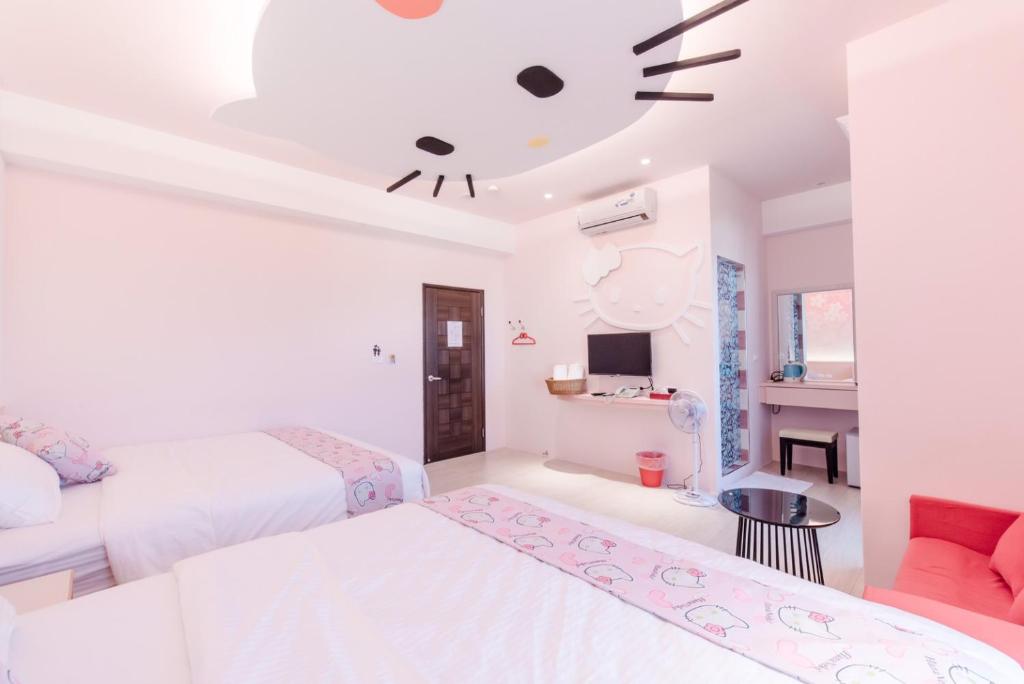 a bedroom with two beds and a ceiling with a cat on it at Tiamo B&B in Magong