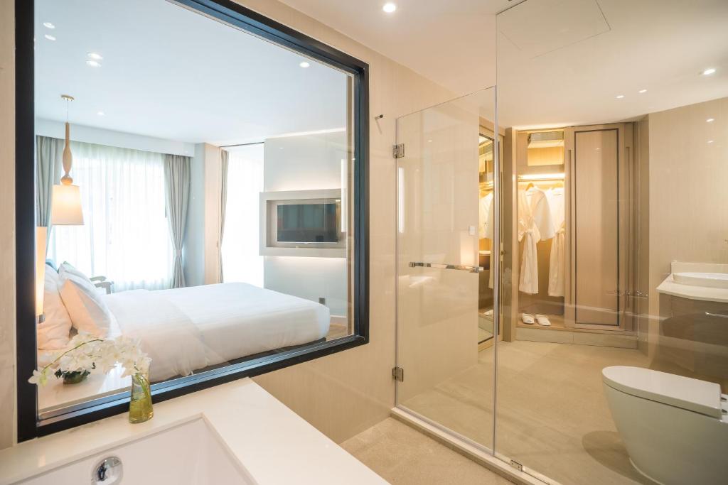 a bathroom with a bed and a glass shower at Avani+ Hua Hin Resort in Cha Am