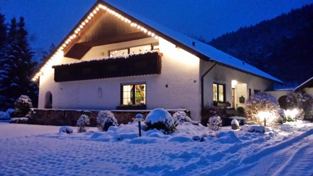 a house covered in snow at night with lights at Haus Annemarie in Goldkronach