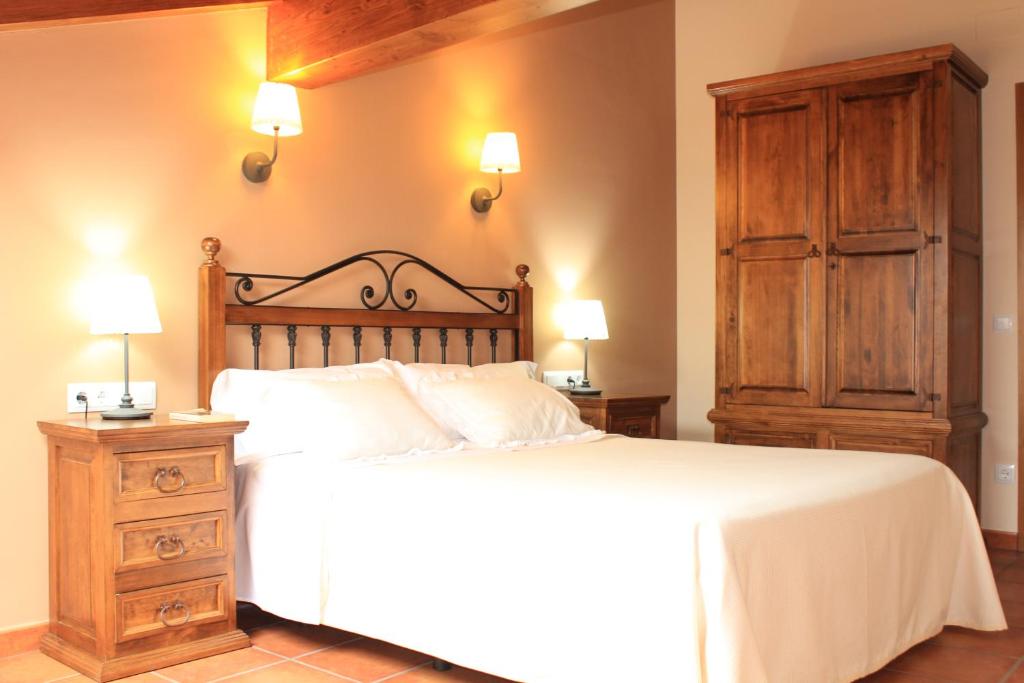 1 dormitorio con 1 cama, vestidor y lámparas en Apartamentos Los Rosales de Isabel en Corral de Ayllón