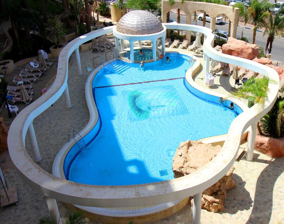 a water slide in a pool with a gazebo at Sunset apartment's Residence du Golf in Eilat