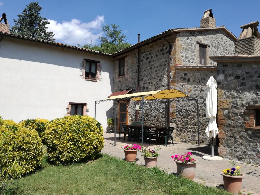 an outdoor patio with an umbrella and a building at B&B Poggio Stallone in Orvieto