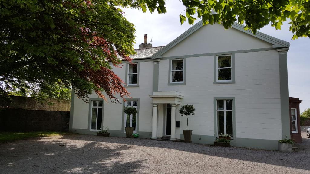 uma casa branca com uma entrada em Croft Hill Guest House em Whitehaven