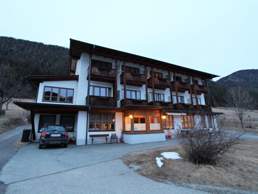 a large building with a car parked in front of it at Cosy Apartment in Weissensee near Ski Lift in Weissensee