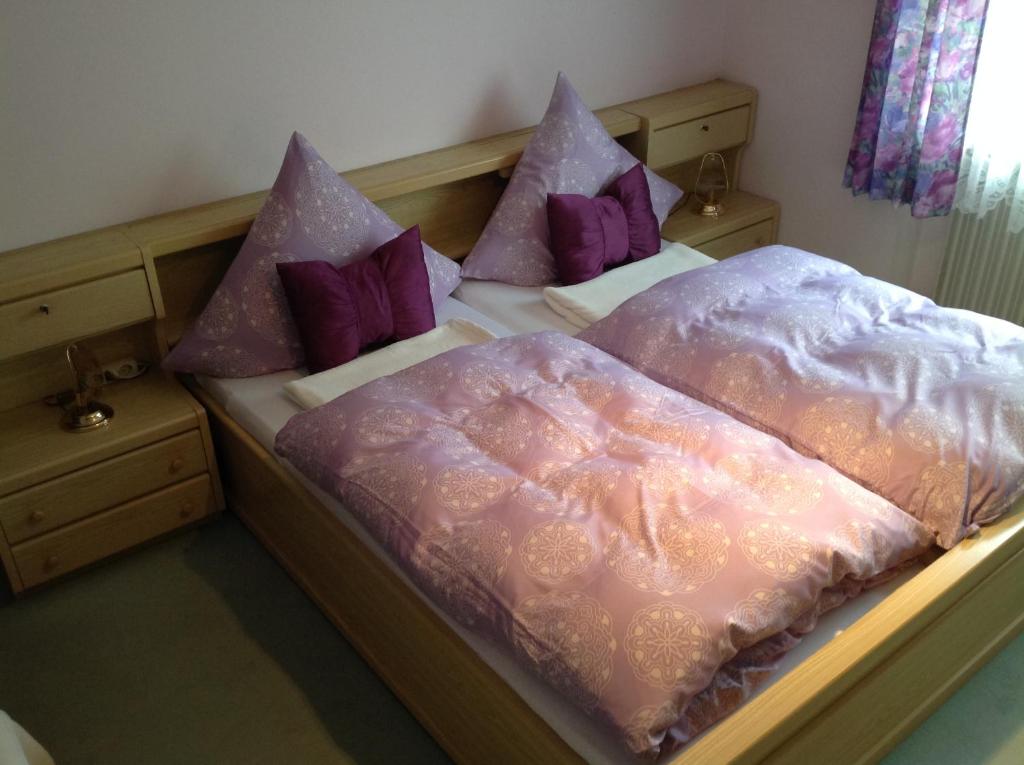 two beds with pink and purple pillows on them at Ferienwohnungen Hölzl in Schönau am Königssee