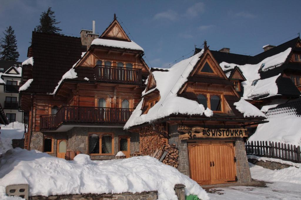 een groot houten huis bedekt met sneeuw bij Swistowka in Zakopane