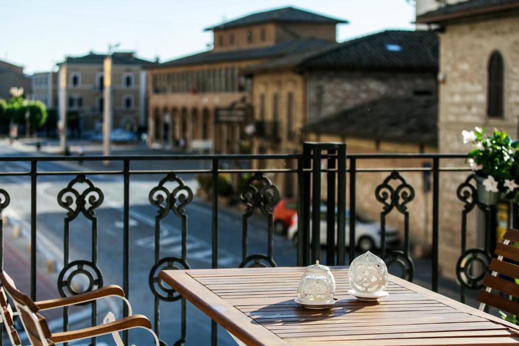 una mesa de madera en un balcón con vistas a la ciudad en Sunset House La Terrazza, en Asís