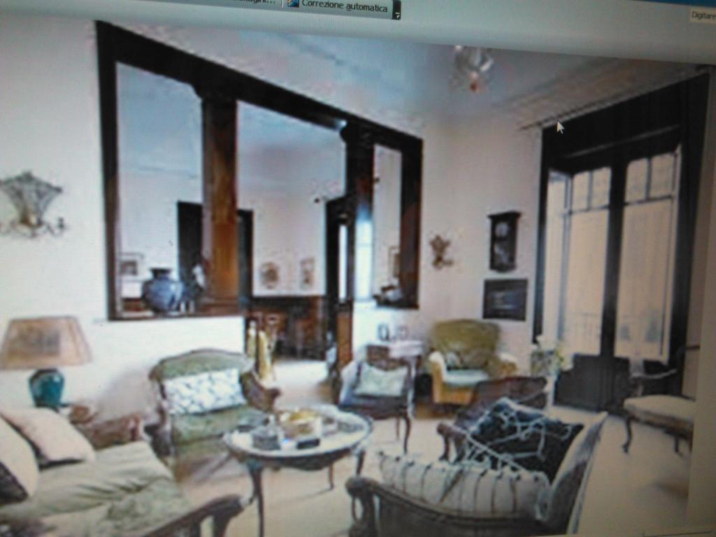 uma sala de estar com um sofá, cadeiras e uma mesa em Rosella Bianchi em Palermo