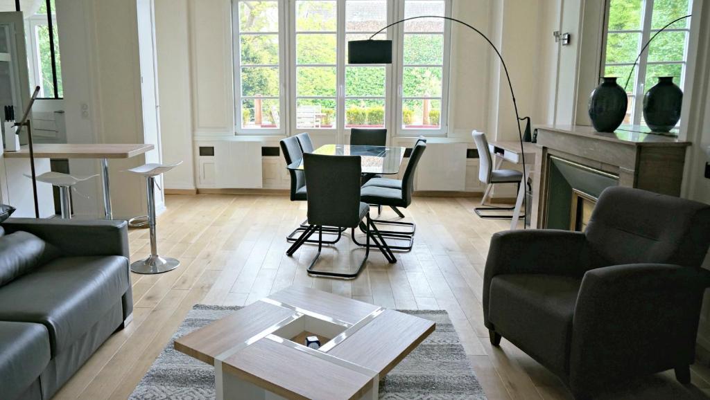 ein Wohnzimmer mit einem Sofa, einem Tisch und Stühlen in der Unterkunft Little Suite - Colas in Lille