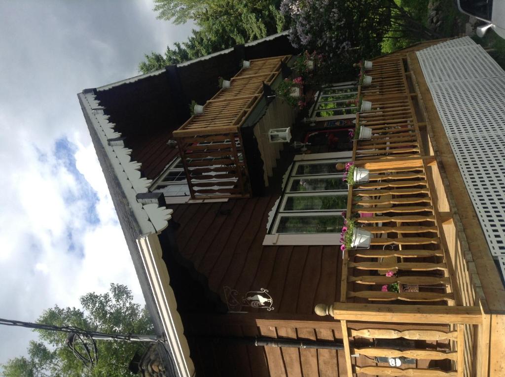 a house with a deck with potted plants on it at Gite la Tourelle du Cap in La Malbaie