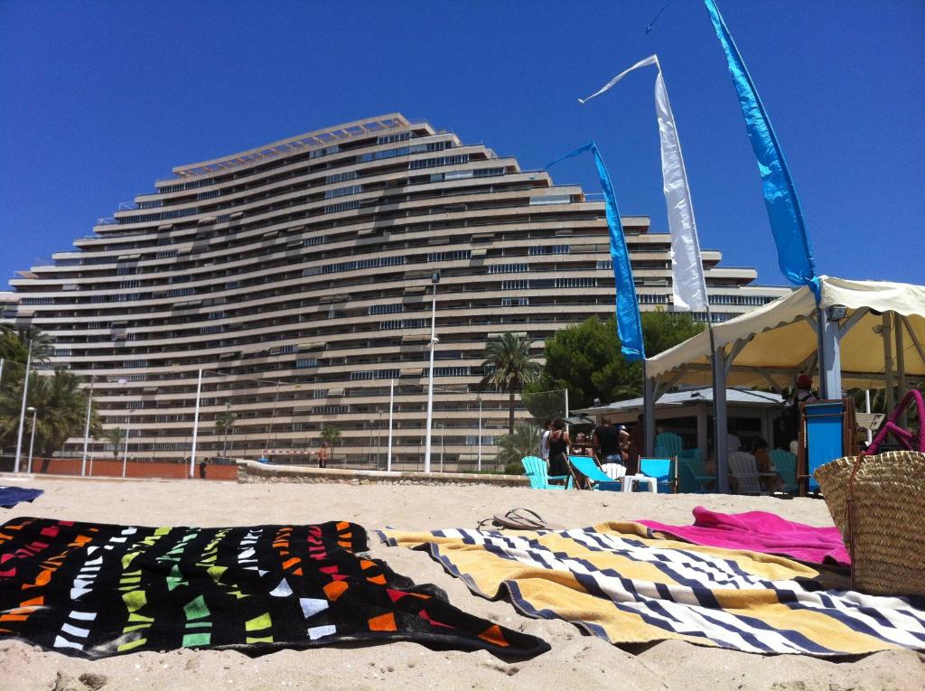 a large building on the beach with towels on the sand at Florazar de Ensueño in Cullera