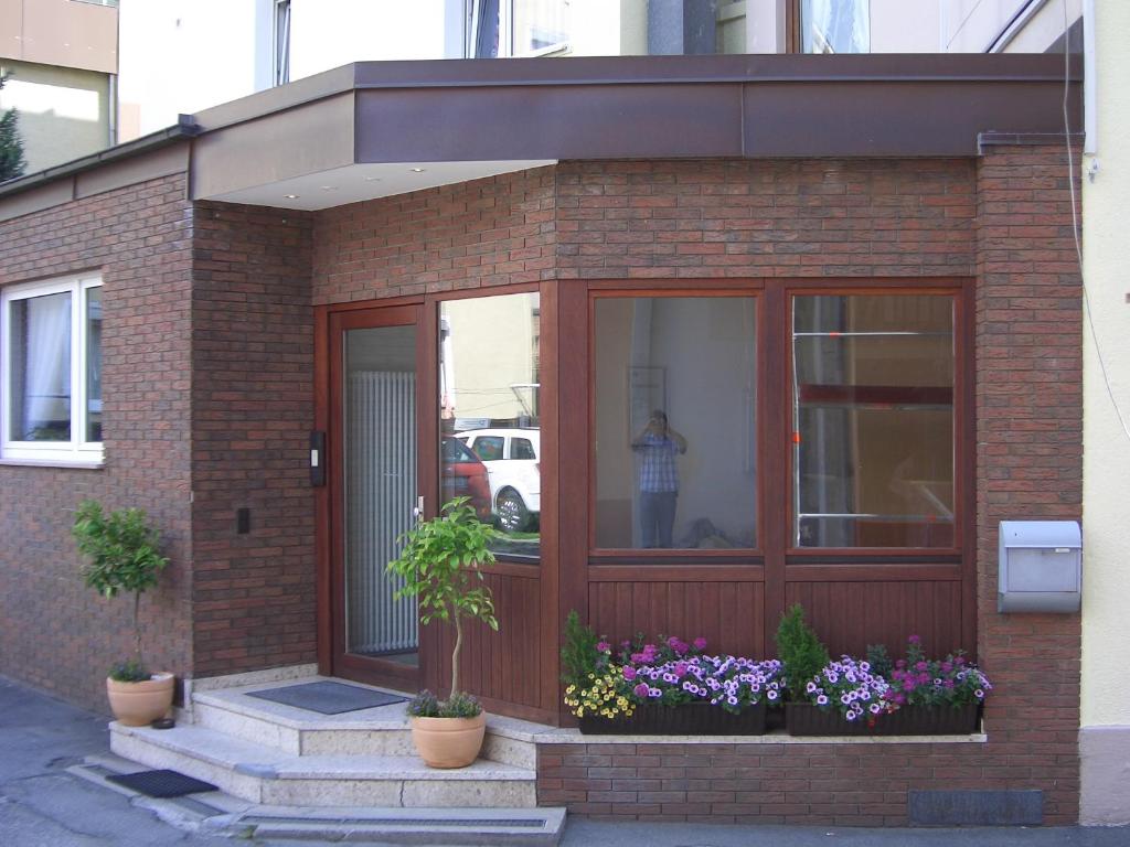 a brick building with flowers in front of a door at Hotel Feuerbacher Hof in Stuttgart