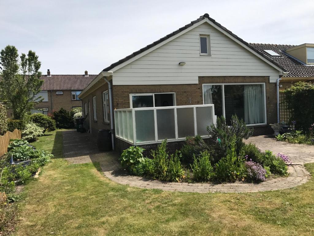 une maison avec un jardin en face dans l'établissement huize Louwra, à Egmond-Binnen