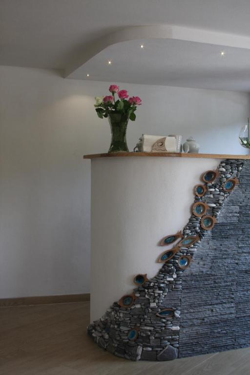 a row of wine glasses on a wall with a vase at B&B Le Giare in Monterosso al Mare