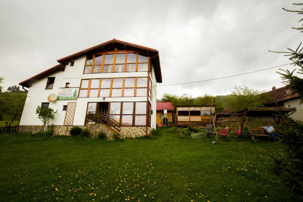 a large white building with windows in a yard at Casa Hille in Măgura