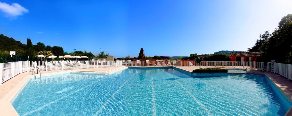 une grande piscine d'eau bleu clair dans l'établissement Le Domaine du Thronnet, à Figanières
