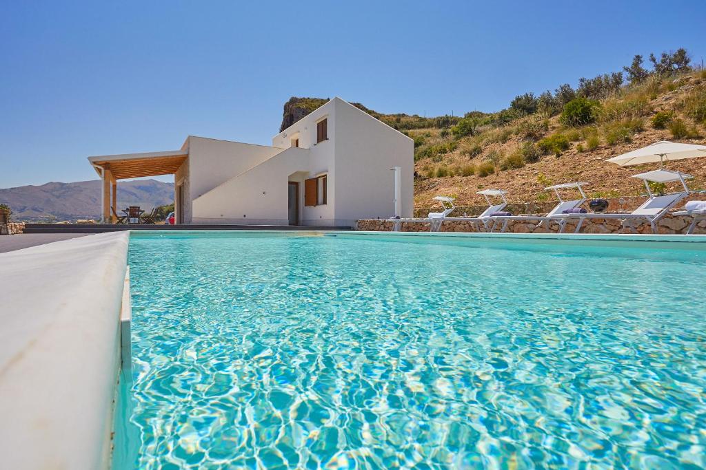 a villa with a swimming pool in front of a house at Villa dell'Artista in Scopello