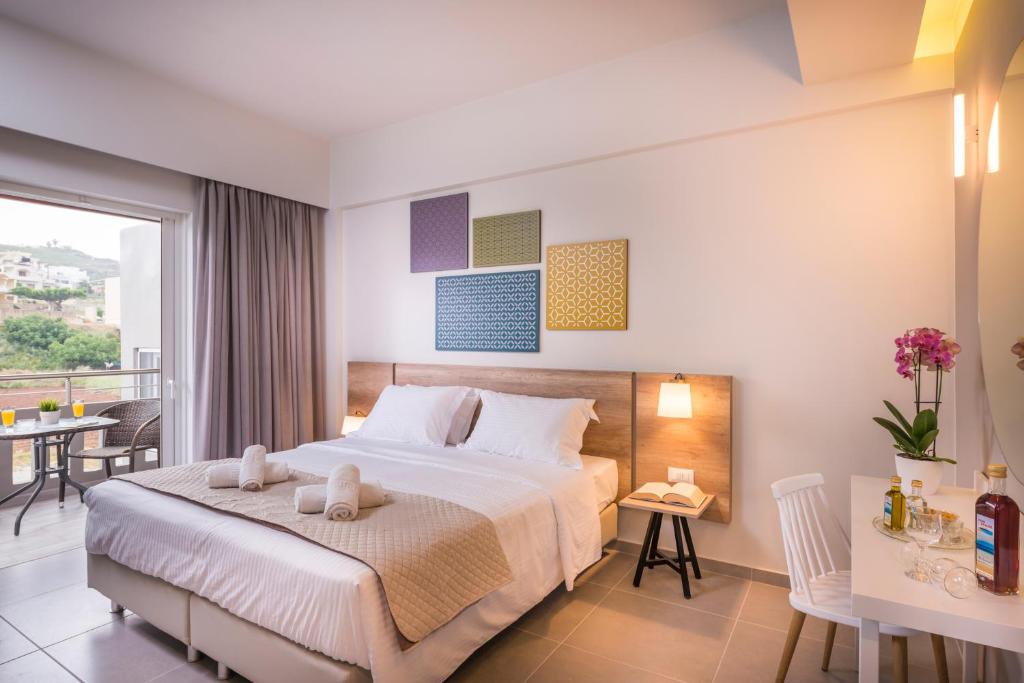 スタロスにあるIRINI STALOS Apartmentsのベッドとバルコニー付きのホテルルーム