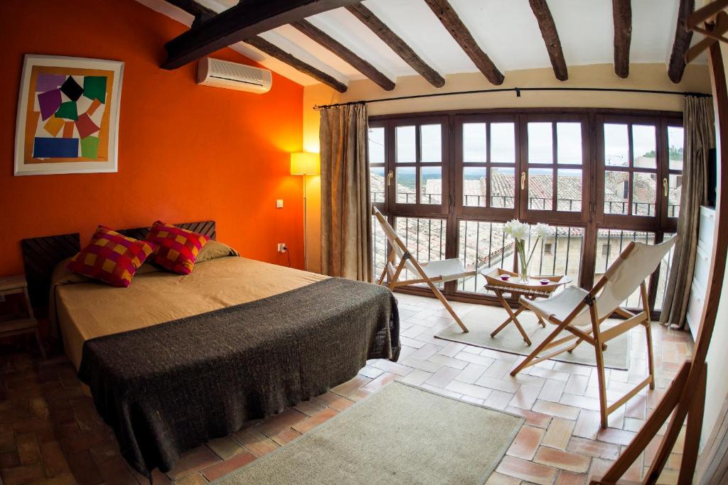 1 dormitorio con paredes de color naranja, 1 cama y 1 mesa en Lo Raconet de la Plaça, en Calaceite