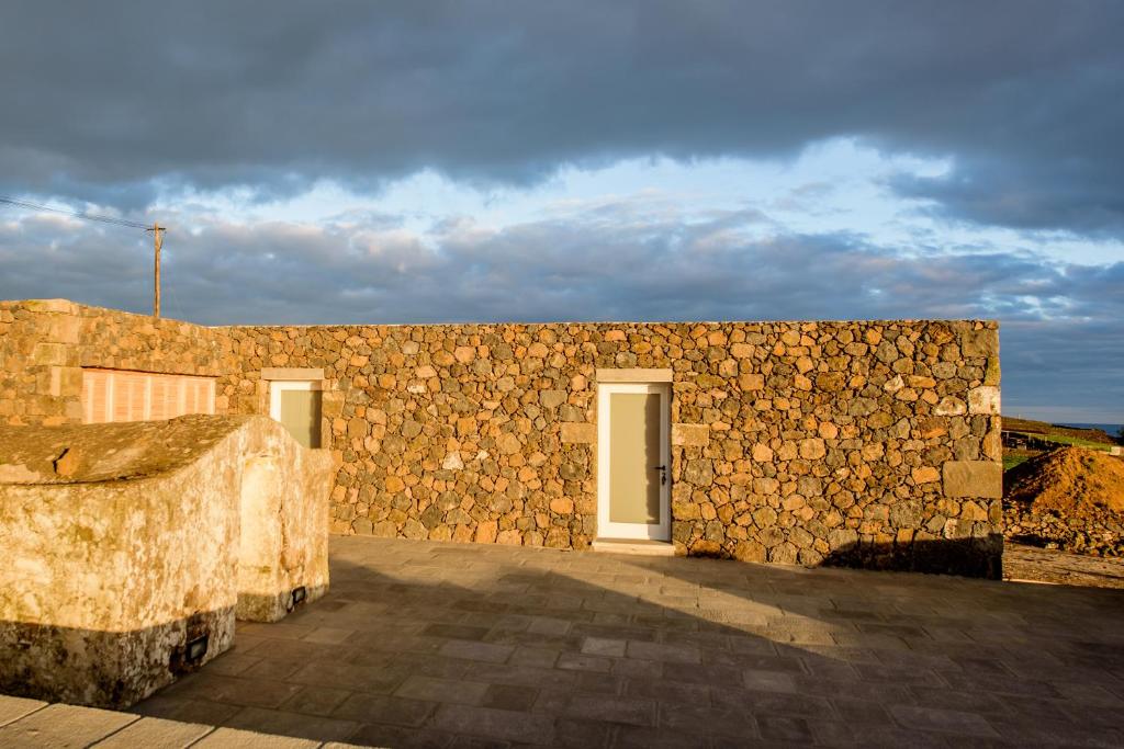 una pared de piedra con una puerta en un edificio en Casa Branca da Vaquinha, en Angra do Heroísmo