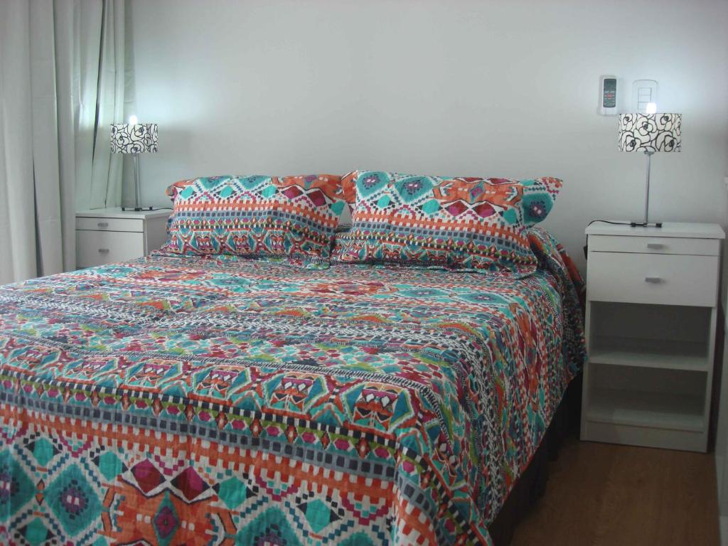 1 dormitorio con 1 cama con un edredón colorido en Rent Apart Caballito 2 en Buenos Aires