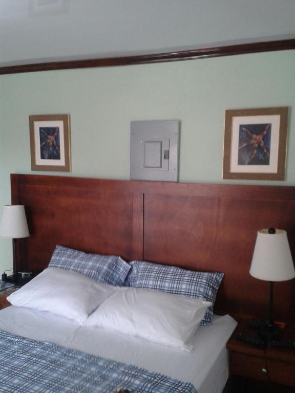 a bedroom with a bed with a wooden head board at Believe Caribbean Apartment in Bridgetown