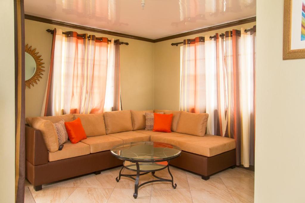 a living room with a couch and a glass table at Believe Caribbean Apartment in Bridgetown