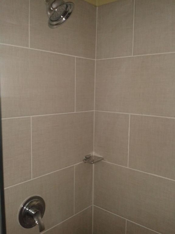 a bathroom shower with a tiled shower stall at Believe Caribbean Apartment in Bridgetown