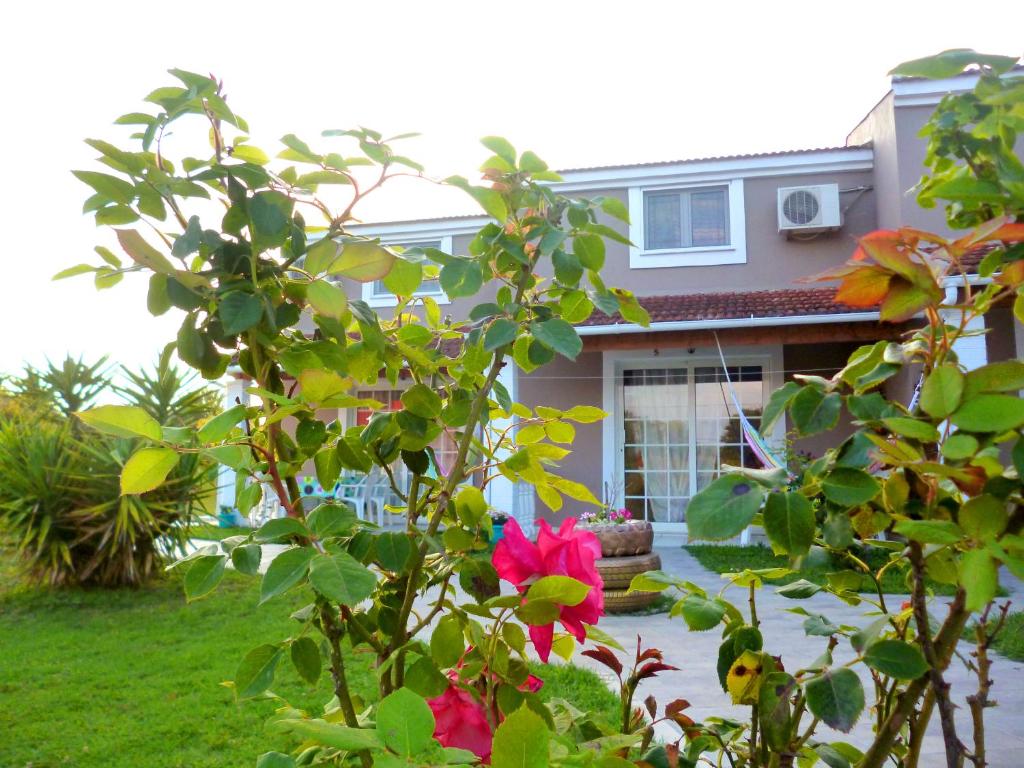 ein Haus mit einer rosa Blume im Vorgarten in der Unterkunft Demis Apartments in Sidari