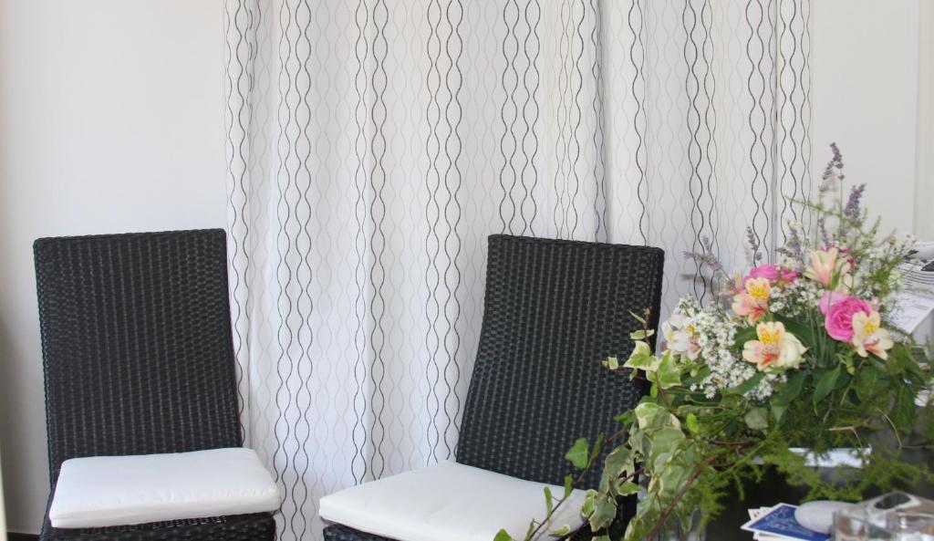 two chairs sitting next to a table with flowers at B&B Le Giare in Monterosso al Mare