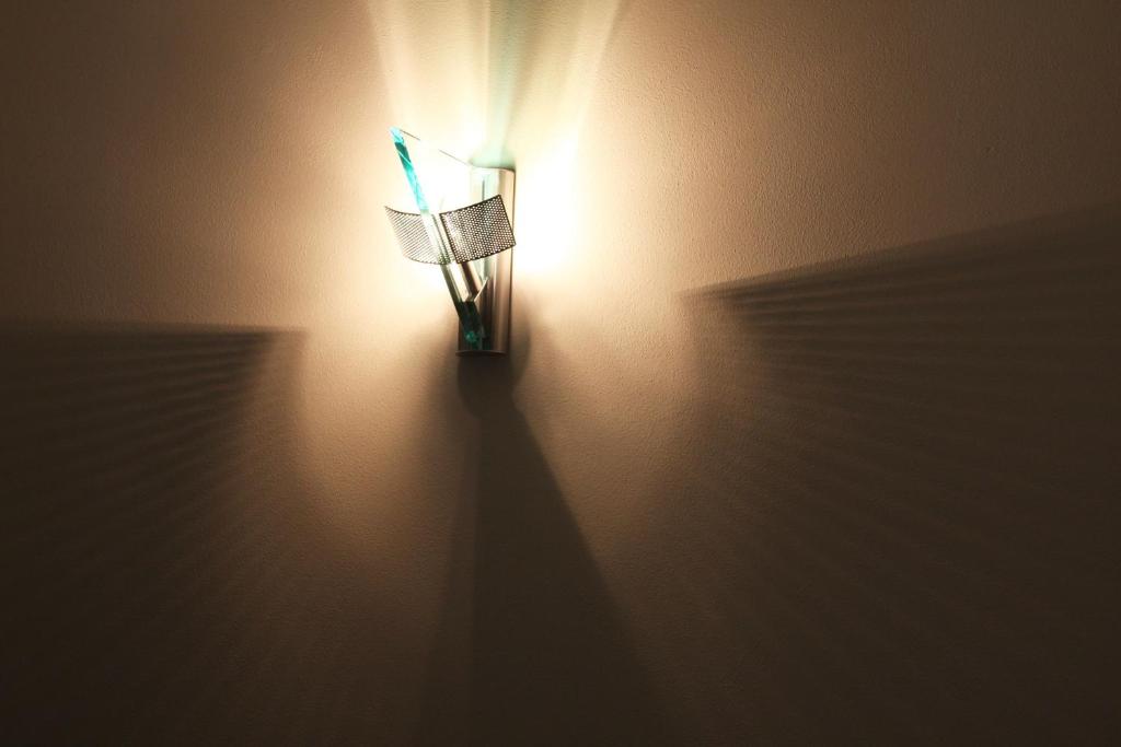 a light on a wall with a chair on it at B&B Le Giare in Monterosso al Mare
