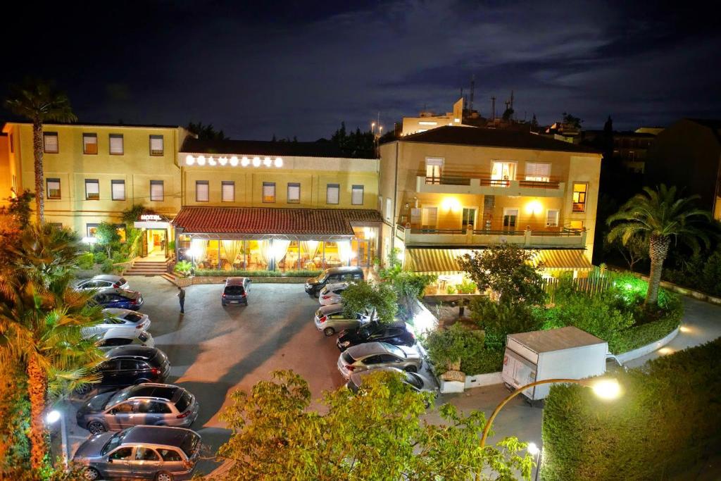 a parking lot with cars parked in front of a building at Hotel Belvedere in Canicattì