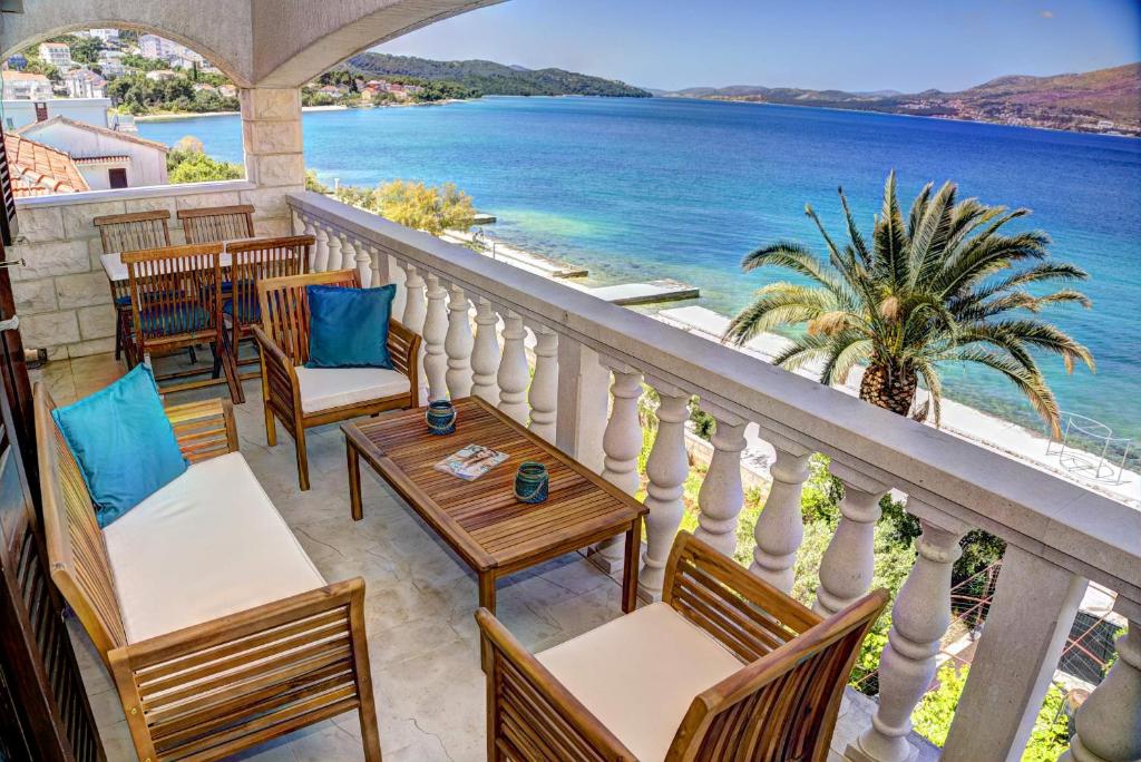 a balcony with tables and chairs and a view of the ocean at Apartment Villa Bralo in Trogir