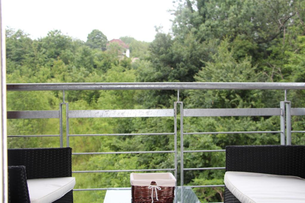 a balcony with two chairs and a view of trees at Perla Lux in Vrnjačka Banja
