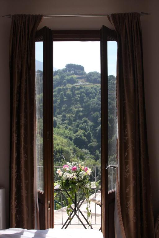 a bedroom with a window with a view of a mountain at B&B Le Giare in Monterosso al Mare