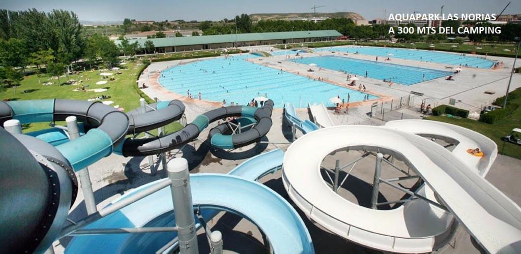 una gran piscina con toboganes azules y blancos en Bungalows & Albergue La Playa, en Logroño