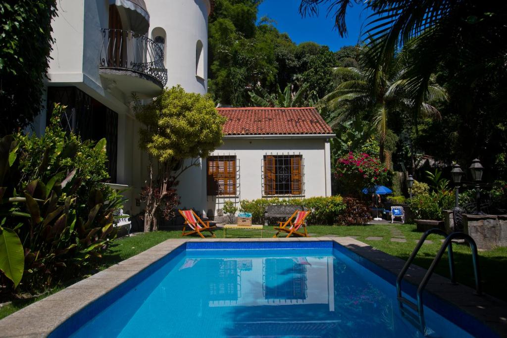 una villa con piscina di fronte a una casa di Casa Beleza a Rio de Janeiro