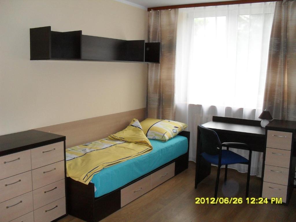 a small bedroom with a bed and a desk at Dom Studencki Atol in Krakow