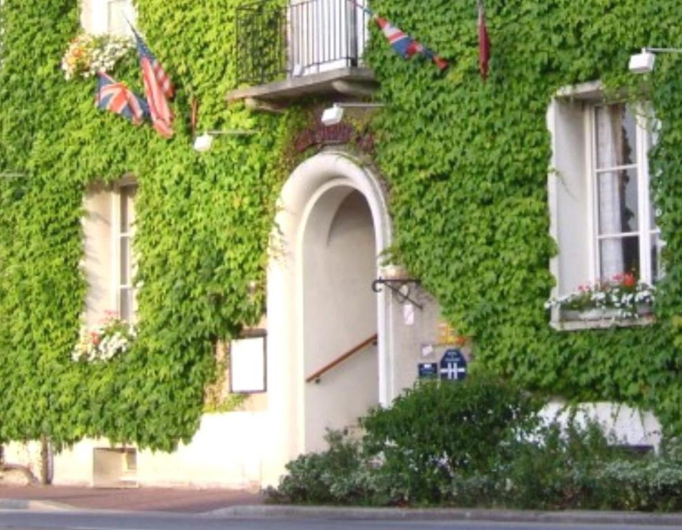 un edificio ricoperto di edera verde con porta e finestre di Auberge du Vieux Chateau a Saint-Sauveur-le-Vicomte