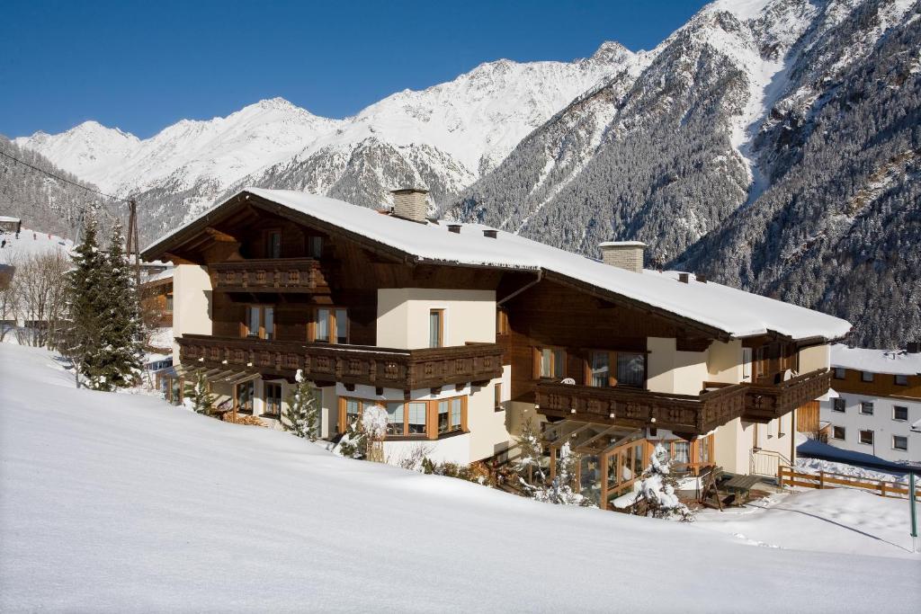 ein Gebäude im Schnee mit Bergen im Hintergrund in der Unterkunft Appartement Rangger in Sölden