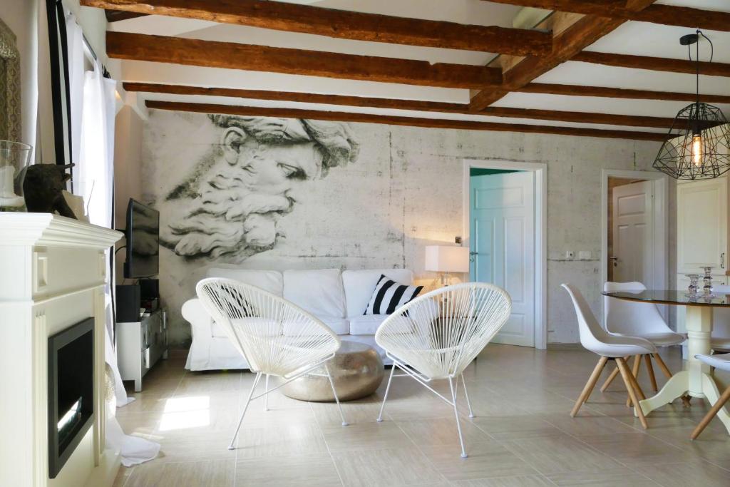 salon z białymi krzesłami i kanapą w obiekcie Bellavista Attic Apartment w mieście Izola