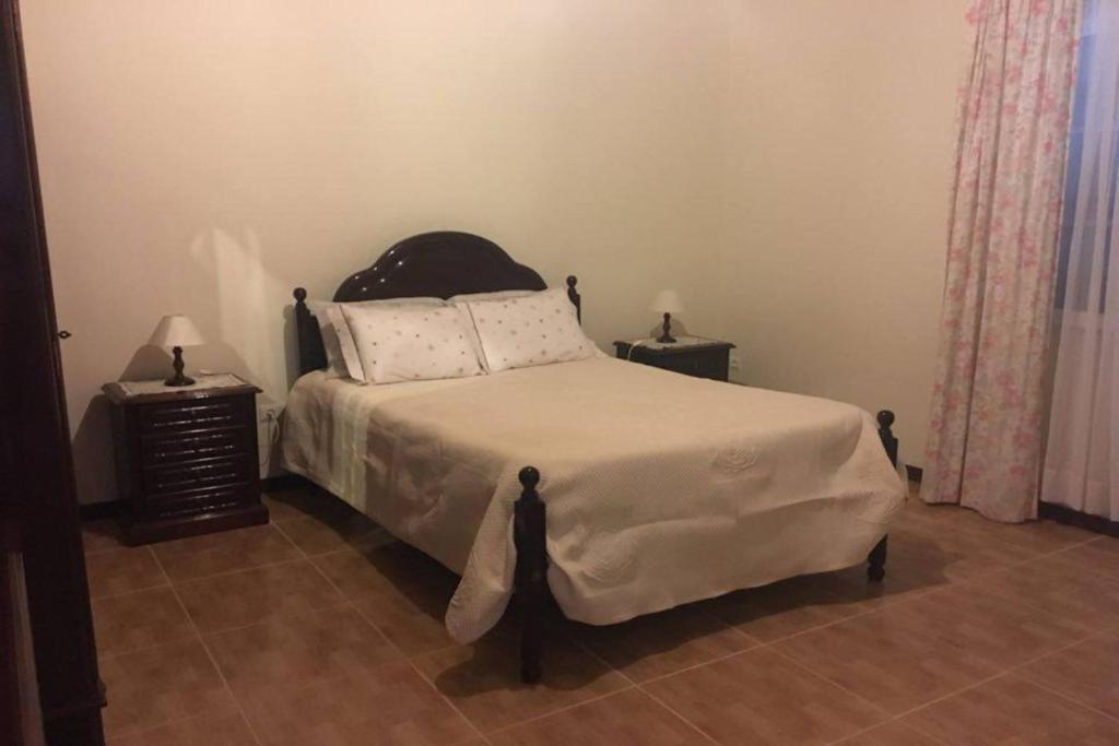 una camera con un letto e due comodini di Casa de Férias Morena Santa Cruz Madeira a Santa Cruz