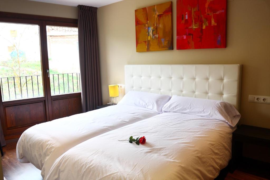 a bedroom with a white bed with roses on it at El Cierzo de Javalambre in Arcos de las Salinas