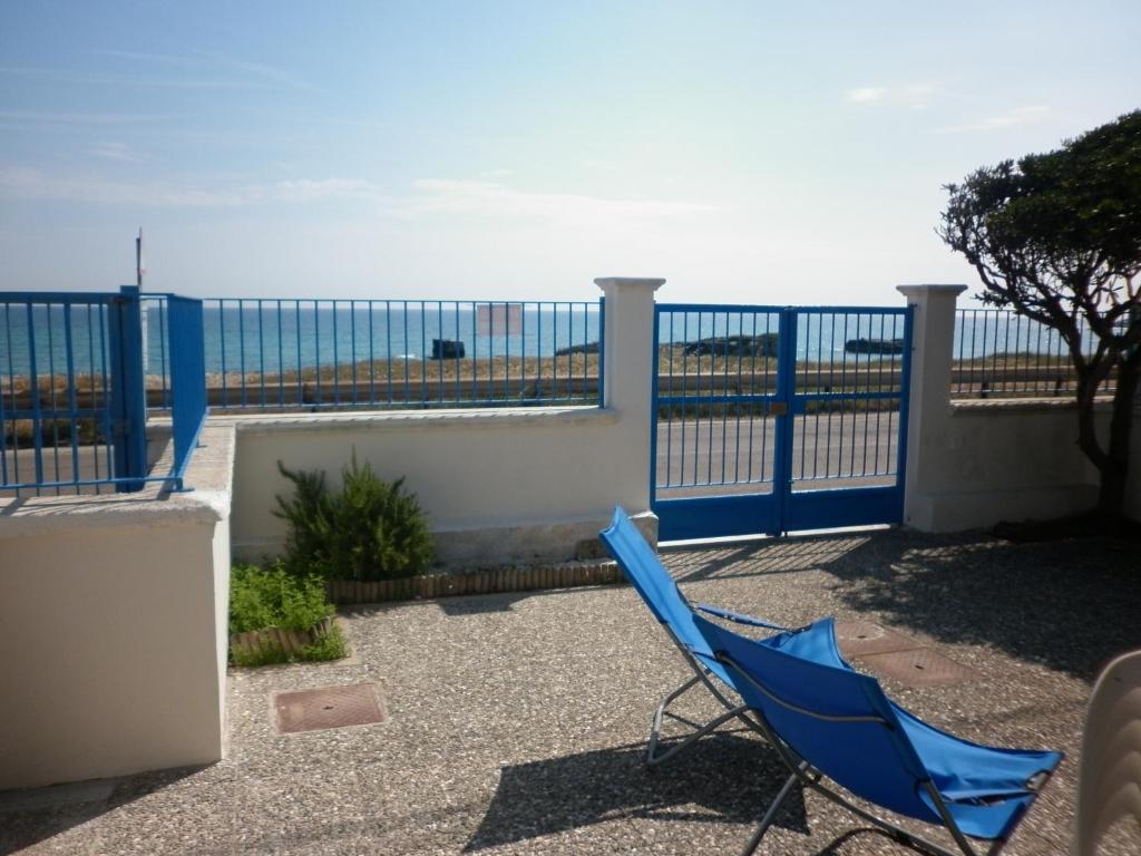 新福卡的住宿－Villino sul mare，阳台的蓝色椅子,背景是大海