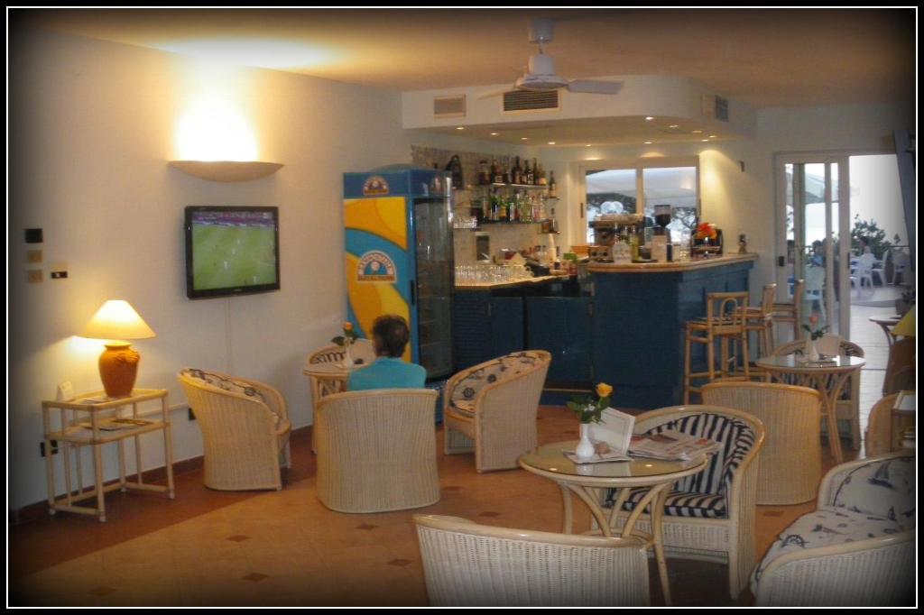 a restaurant with tables and chairs and a bar at Hotel Viticcio in Portoferraio