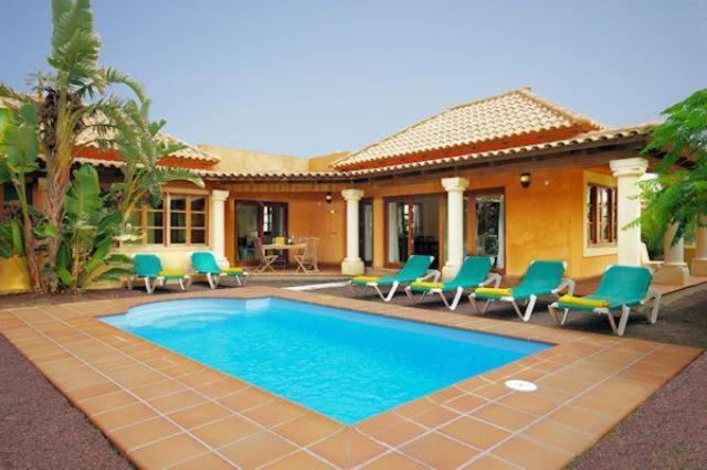 una casa con piscina frente a una casa en Villas Brisas del Mar, en Corralejo