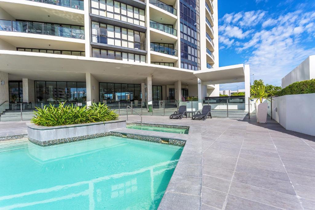 een zwembad voor een gebouw bij Mantra Sierra Grand in Gold Coast