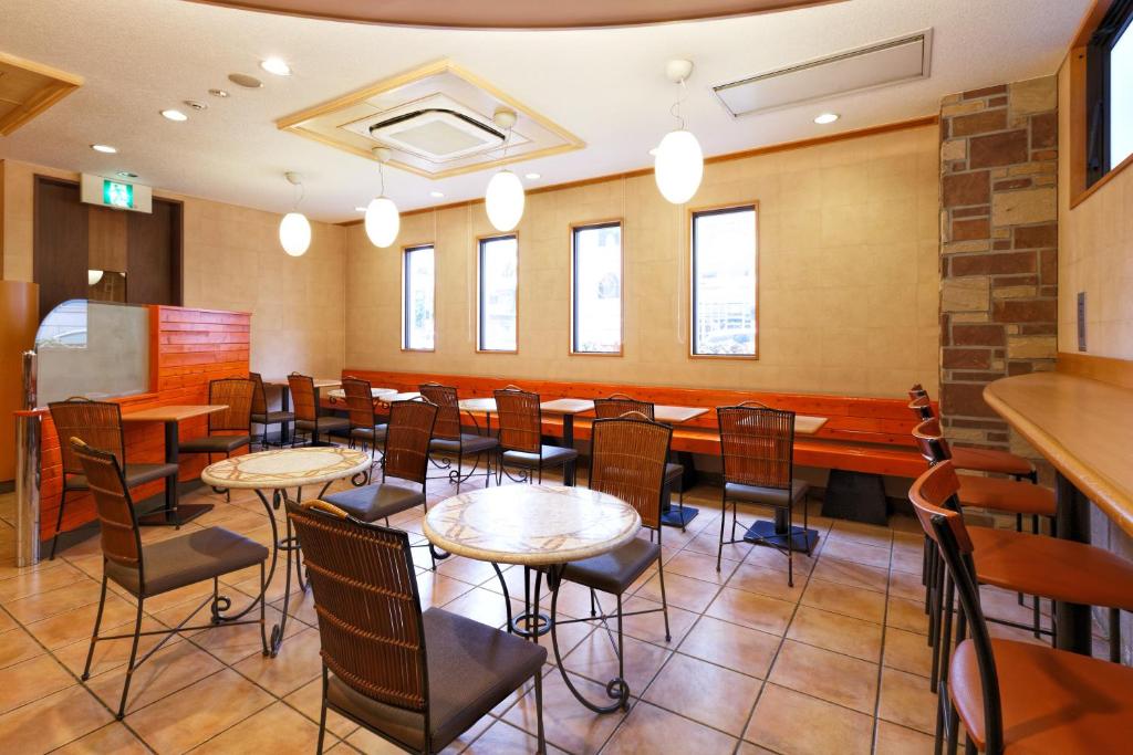 a restaurant with tables and chairs in a room at R&B Hotel Hakata Ekimae 1 in Fukuoka
