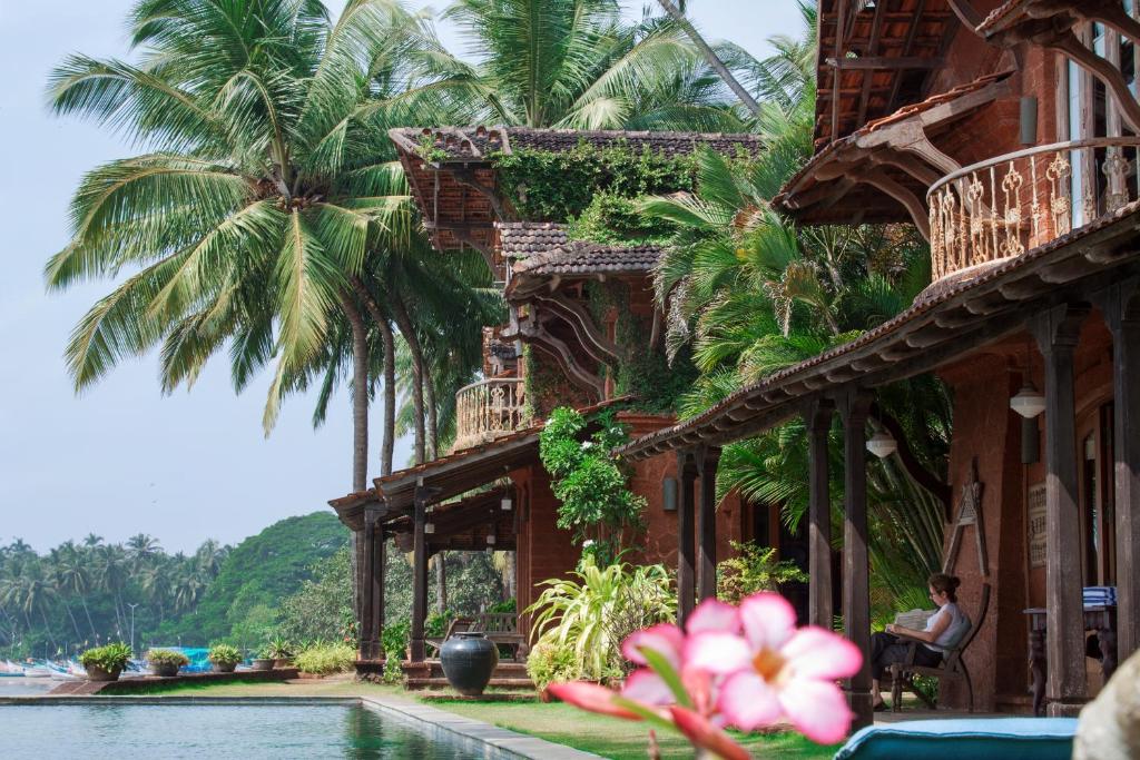 uma mulher sentada numa cadeira ao lado de um edifício em Ahilya By The Sea em Nerul